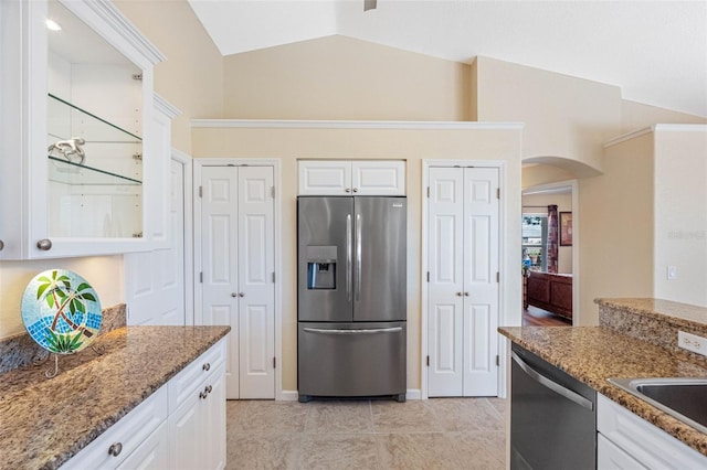 kitchen with stainless steel appliances, lofted ceiling, stone countertops, and white cabinetry