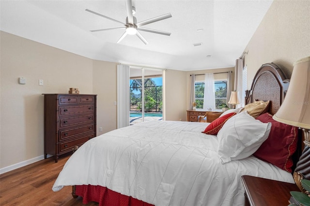 bedroom with wood finished floors, a sunroom, a ceiling fan, baseboards, and access to outside