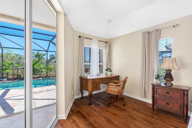 interior space with a sunroom, baseboards, and wood finished floors