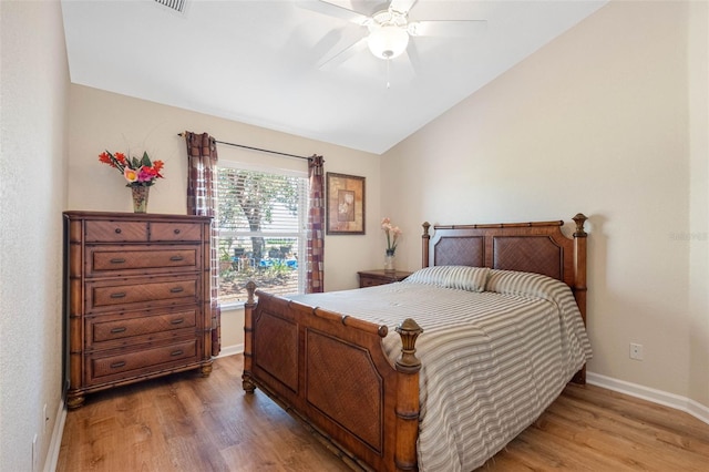 bedroom with a ceiling fan, lofted ceiling, light wood-style flooring, and baseboards