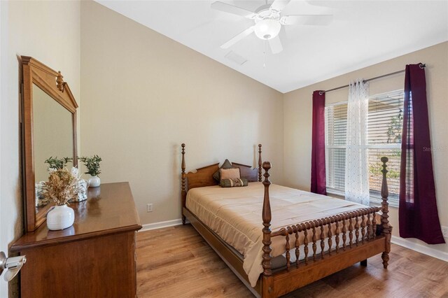 bedroom with lofted ceiling, light wood finished floors, ceiling fan, and baseboards