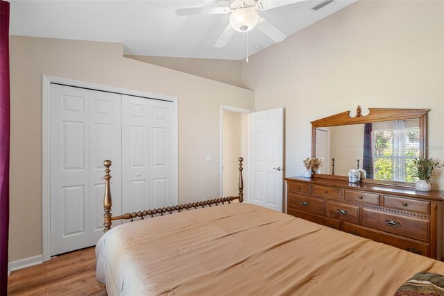 bedroom featuring light wood finished floors, visible vents, lofted ceiling, ceiling fan, and a closet