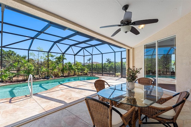 outdoor pool featuring a ceiling fan, glass enclosure, and a patio