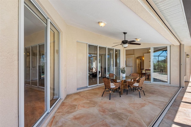 sunroom / solarium featuring arched walkways and a ceiling fan