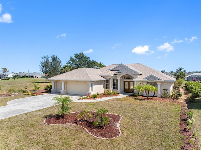 view of front of home featuring driveway, an attached garage, french doors, a front yard, and stucco siding