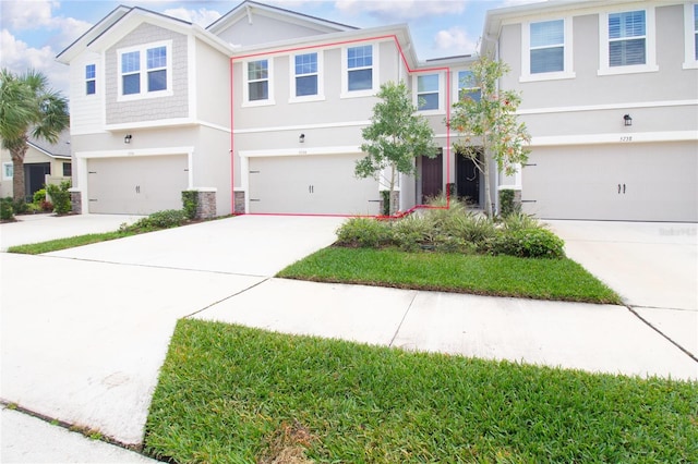 view of front facade featuring an attached garage, concrete driveway, and stucco siding