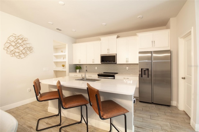 kitchen with visible vents, white cabinets, appliances with stainless steel finishes, light countertops, and a sink