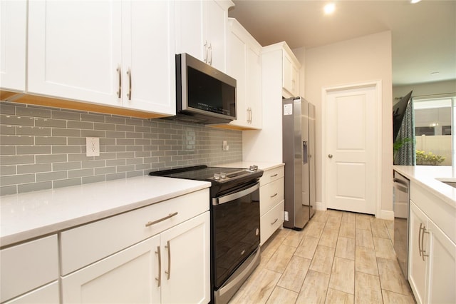 kitchen featuring tasteful backsplash, appliances with stainless steel finishes, white cabinets, and light countertops