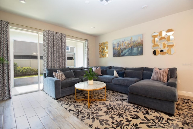 living area featuring plenty of natural light, visible vents, and baseboards