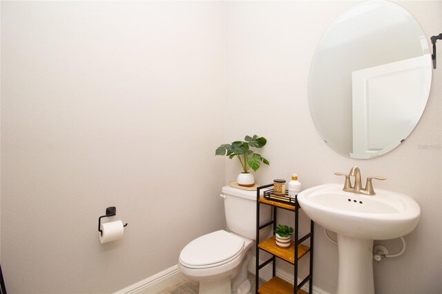 bathroom featuring a sink, toilet, and baseboards