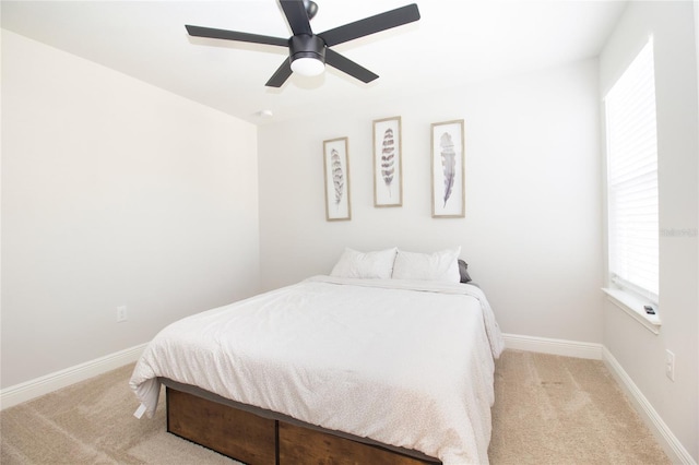 carpeted bedroom with ceiling fan and baseboards