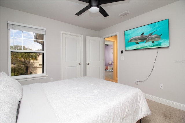 carpeted bedroom featuring baseboards, visible vents, and a ceiling fan