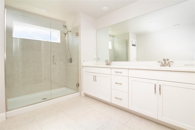 bathroom with a sink, double vanity, tile patterned flooring, and a shower stall