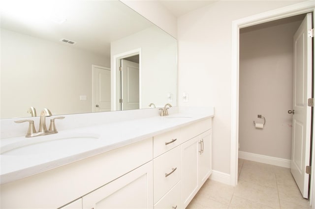 bathroom featuring double vanity, visible vents, a sink, and tile patterned floors