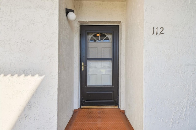 property entrance with stucco siding