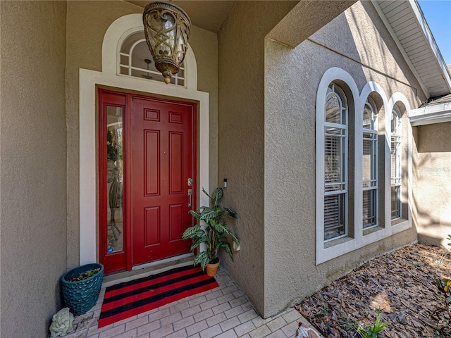 view of exterior entry with stucco siding