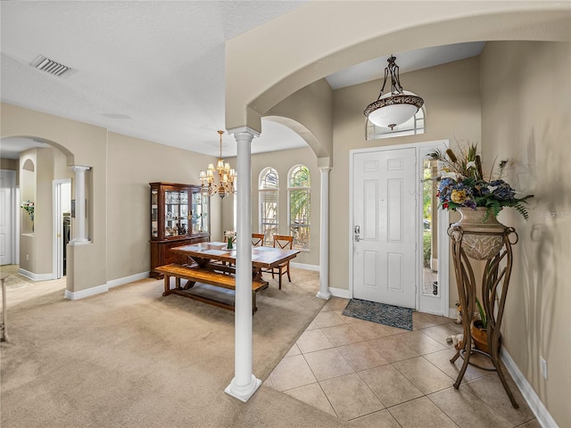 entryway featuring decorative columns, visible vents, and arched walkways