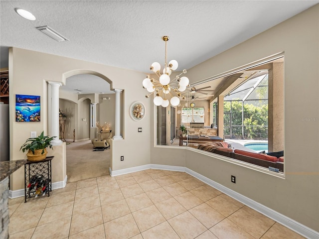 dining room featuring light tile patterned floors, arched walkways, visible vents, and ornate columns