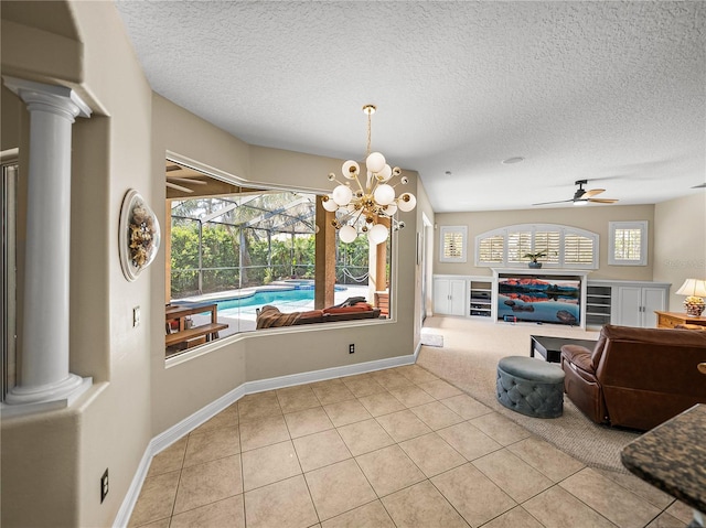 interior space featuring ornate columns, a textured ceiling, a sunroom, and tile patterned floors