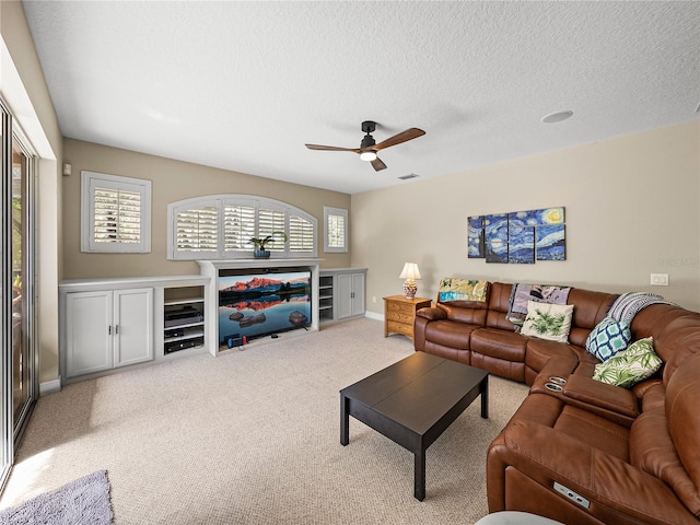 carpeted living room with visible vents, ceiling fan, a textured ceiling, and baseboards