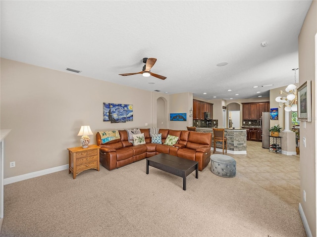 living room featuring visible vents, arched walkways, ceiling fan, and baseboards