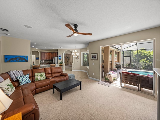 living room with arched walkways, ceiling fan, light carpet, a sunroom, and visible vents