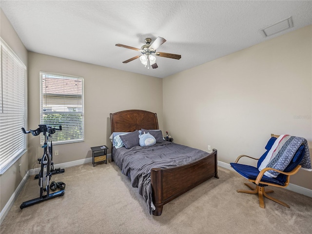 bedroom with baseboards, visible vents, a ceiling fan, a textured ceiling, and carpet floors