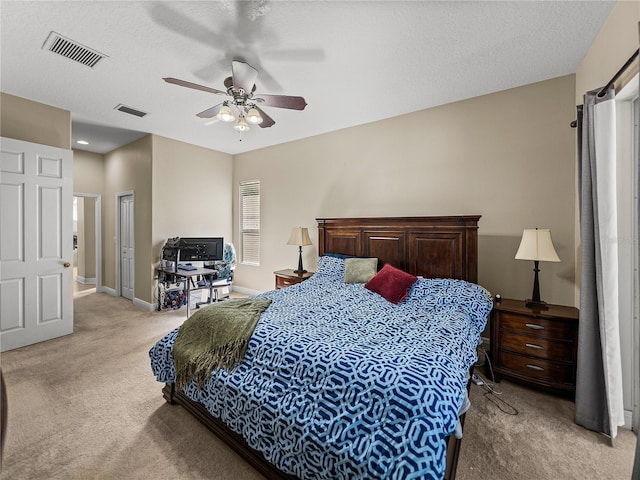 bedroom featuring light carpet, a textured ceiling, visible vents, and baseboards