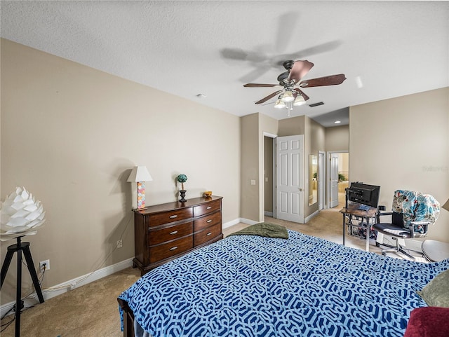 carpeted bedroom featuring a ceiling fan, baseboards, visible vents, and a textured ceiling