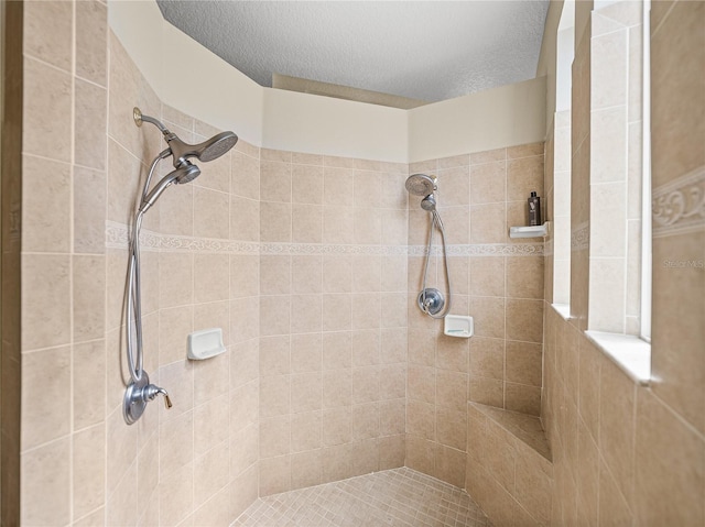 full bathroom with a textured ceiling and tiled shower