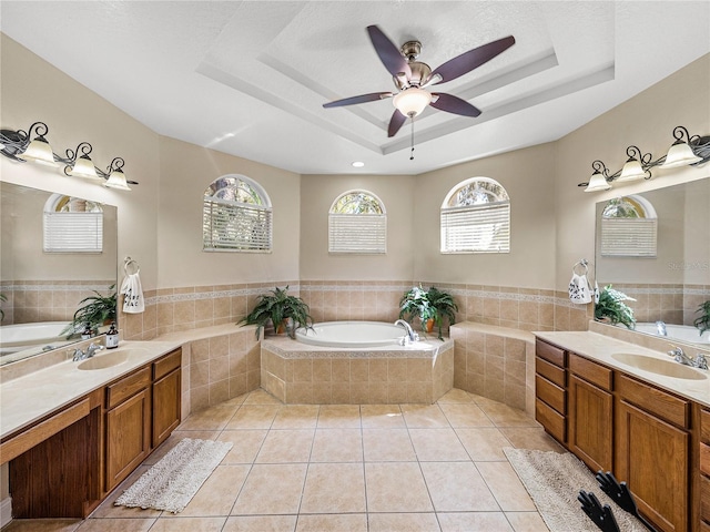 bathroom featuring a tray ceiling, a wealth of natural light, and tile patterned floors