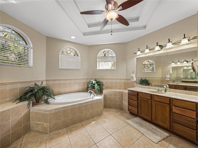 bathroom featuring vanity, a raised ceiling, a bath, and tile patterned floors