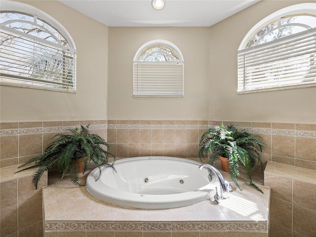 full bath with a tub with jets and plenty of natural light