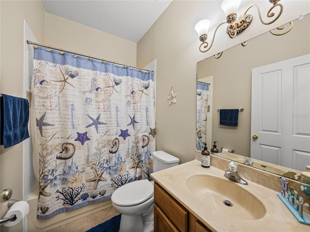 bathroom with a textured ceiling, tile patterned flooring, vanity, and toilet