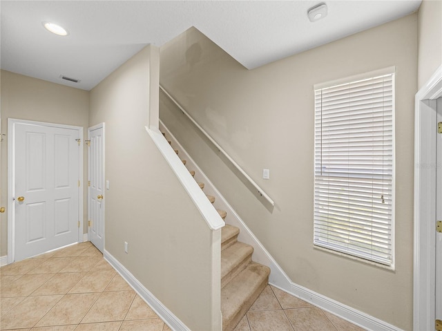 staircase with tile patterned flooring, visible vents, and baseboards