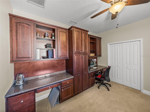 office area featuring a ceiling fan, built in study area, visible vents, and light carpet