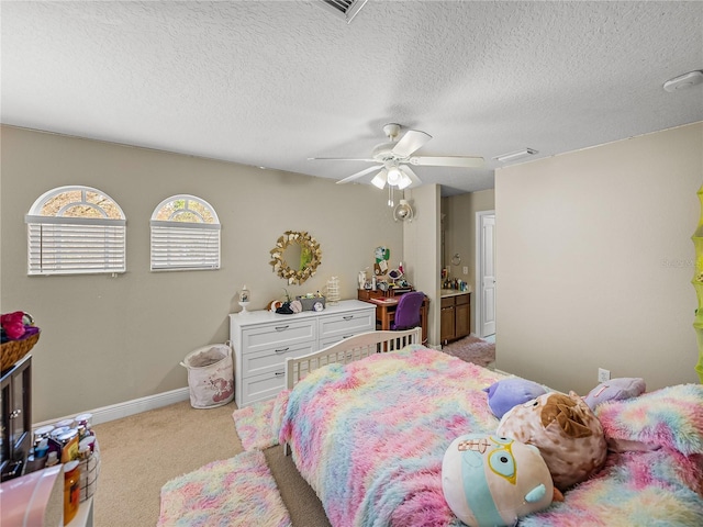 bedroom with light carpet, visible vents, baseboards, a ceiling fan, and a textured ceiling