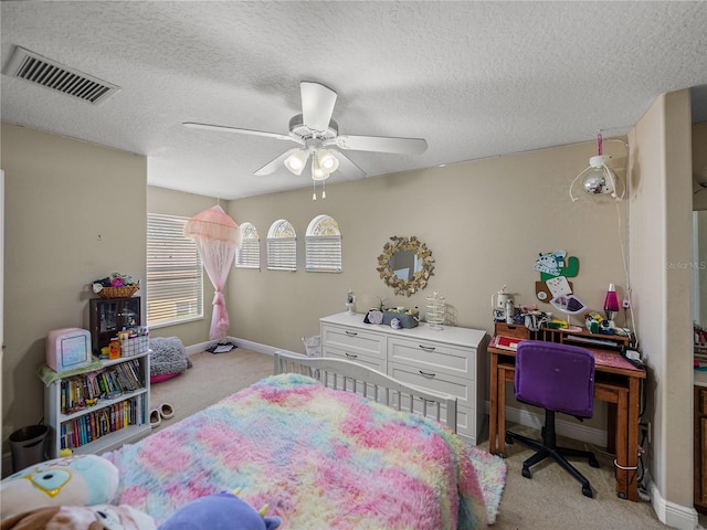 bedroom with a textured ceiling, ceiling fan, light colored carpet, visible vents, and baseboards