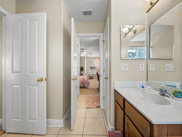 ensuite bathroom with visible vents, ensuite bathroom, vanity, a textured ceiling, and tile patterned flooring