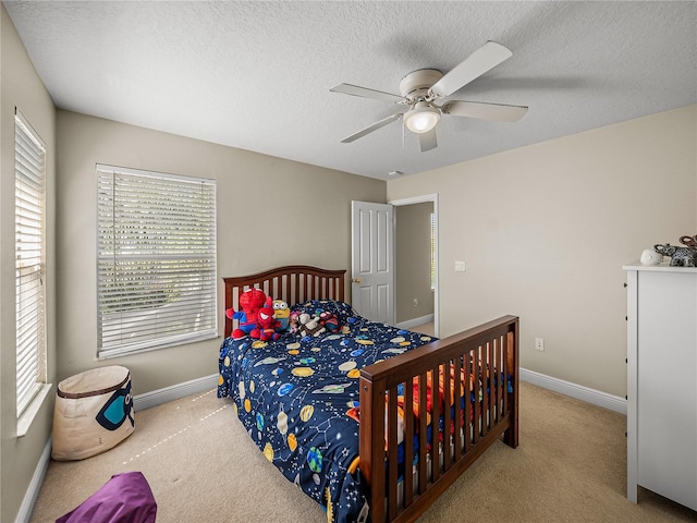 bedroom featuring a textured ceiling, carpet, a ceiling fan, and baseboards