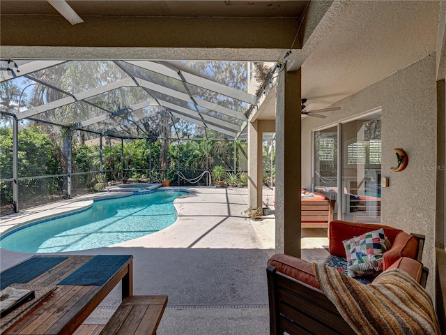 view of pool with a patio, a pool with connected hot tub, a lanai, and a ceiling fan