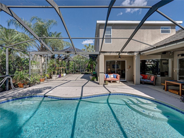 outdoor pool with glass enclosure, ceiling fan, outdoor lounge area, and a patio