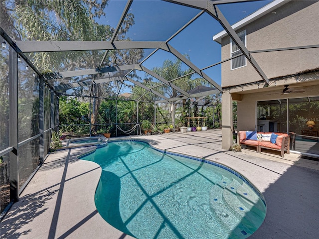 view of pool with a lanai, a pool with connected hot tub, ceiling fan, and a patio