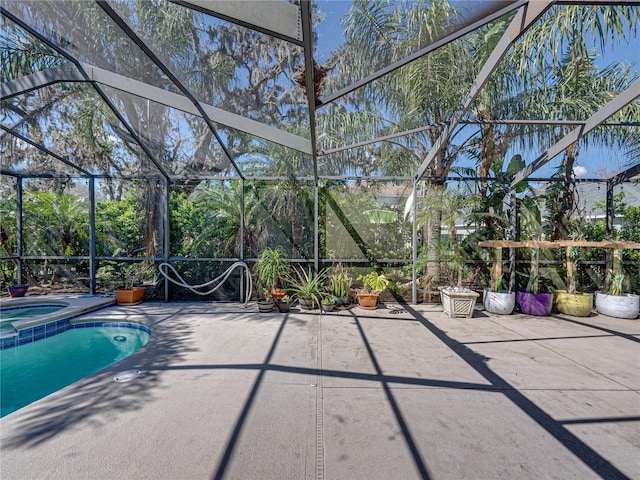 view of swimming pool with glass enclosure, a patio, and an in ground hot tub