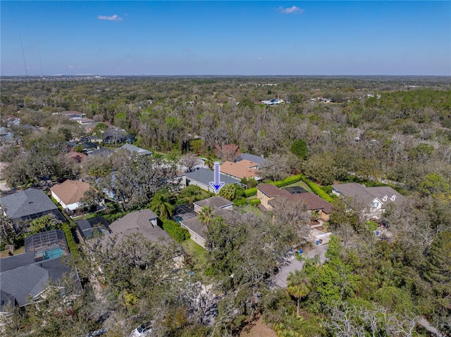 drone / aerial view featuring a wooded view and a residential view