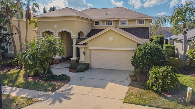 view of front of property with a garage, a shingled roof, concrete driveway, and stucco siding