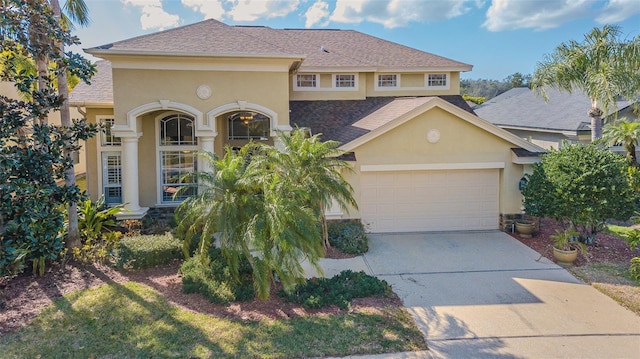 mediterranean / spanish home featuring a garage, roof with shingles, concrete driveway, and stucco siding