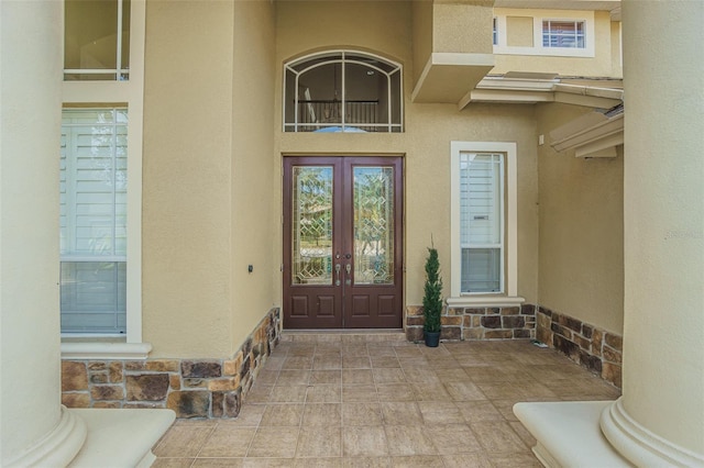 entrance to property featuring stone siding and stucco siding