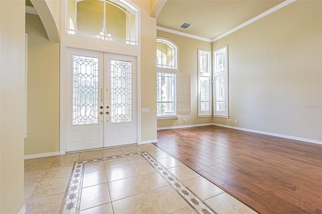 entrance foyer with tile patterned flooring, visible vents, baseboards, french doors, and ornamental molding