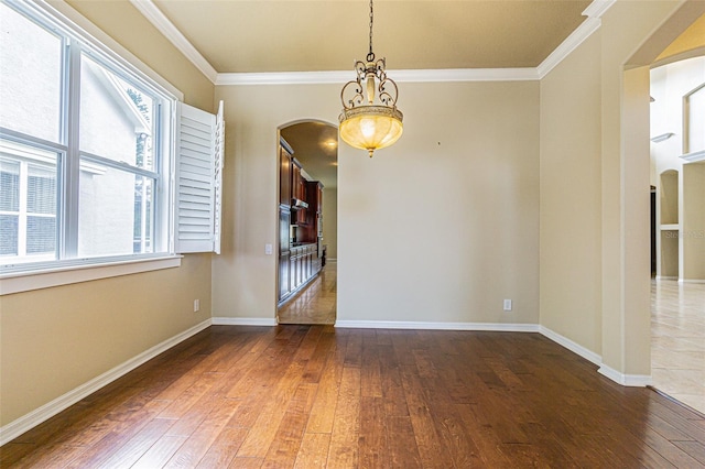 spare room with ornamental molding, baseboards, and hardwood / wood-style floors